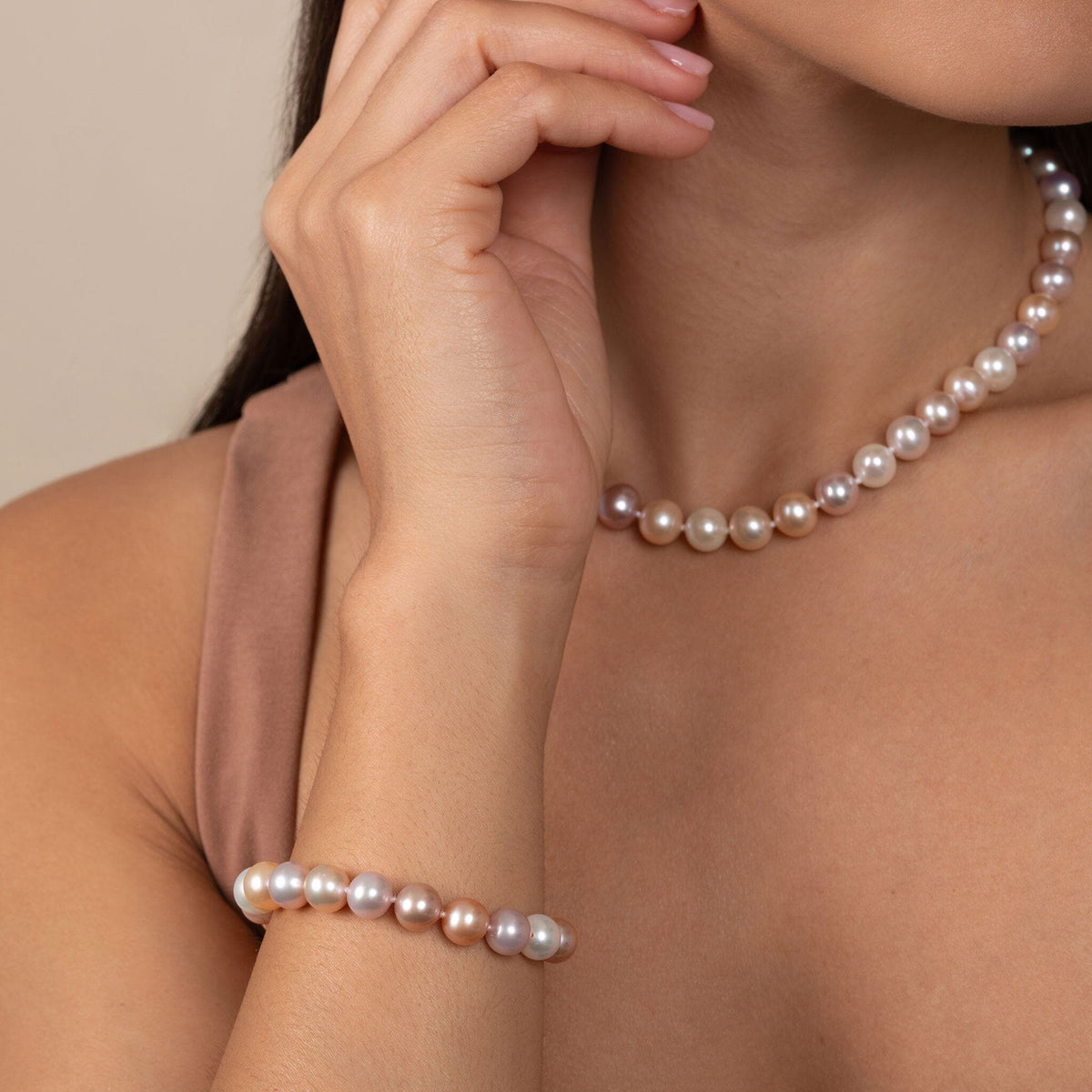 Close-up of a woman wearing an 8.5-9.0 mm Multicolor Freshwater AAA Pearl Bracelet and matching pearl necklace, showcasing lustrous cultured pearls in soft shades of white, pink, and lavender.