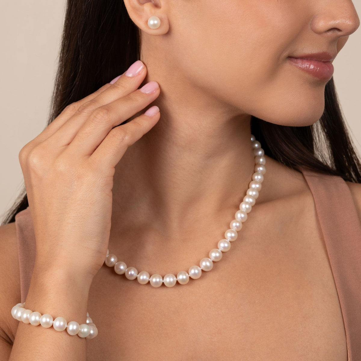 Close-up of a woman wearing a 3-Piece Set of 8.5-9.0 mm White AA+ Freshwater Pearls including a necklace, bracelet, and matching stud earrings.