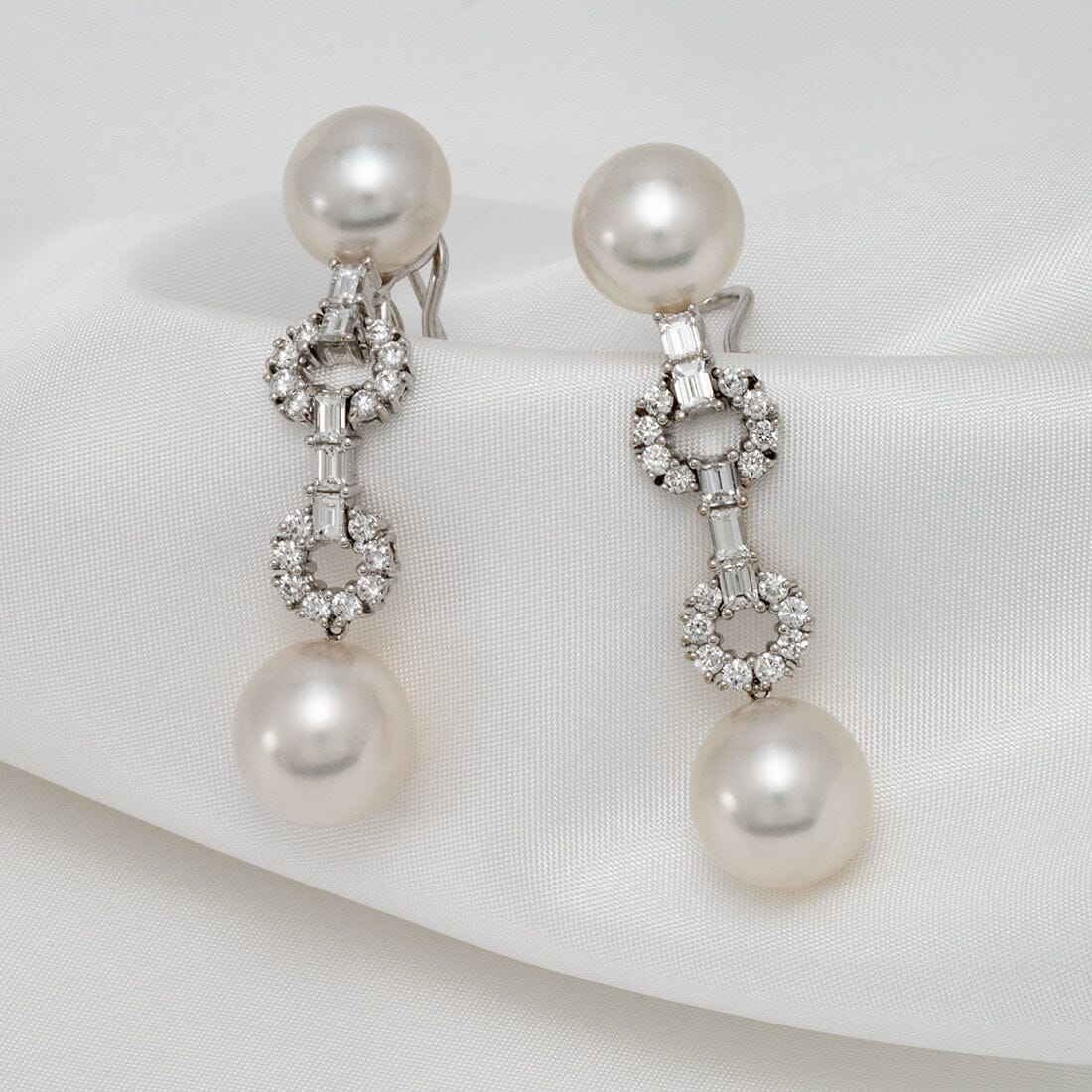 Assael Collection: 10.8-12.7 mm White South Sea Pearl and Diamond Dangle Earrings featuring lustrous white pearls and sparkling diamond accents on a delicate 14K white gold setting.