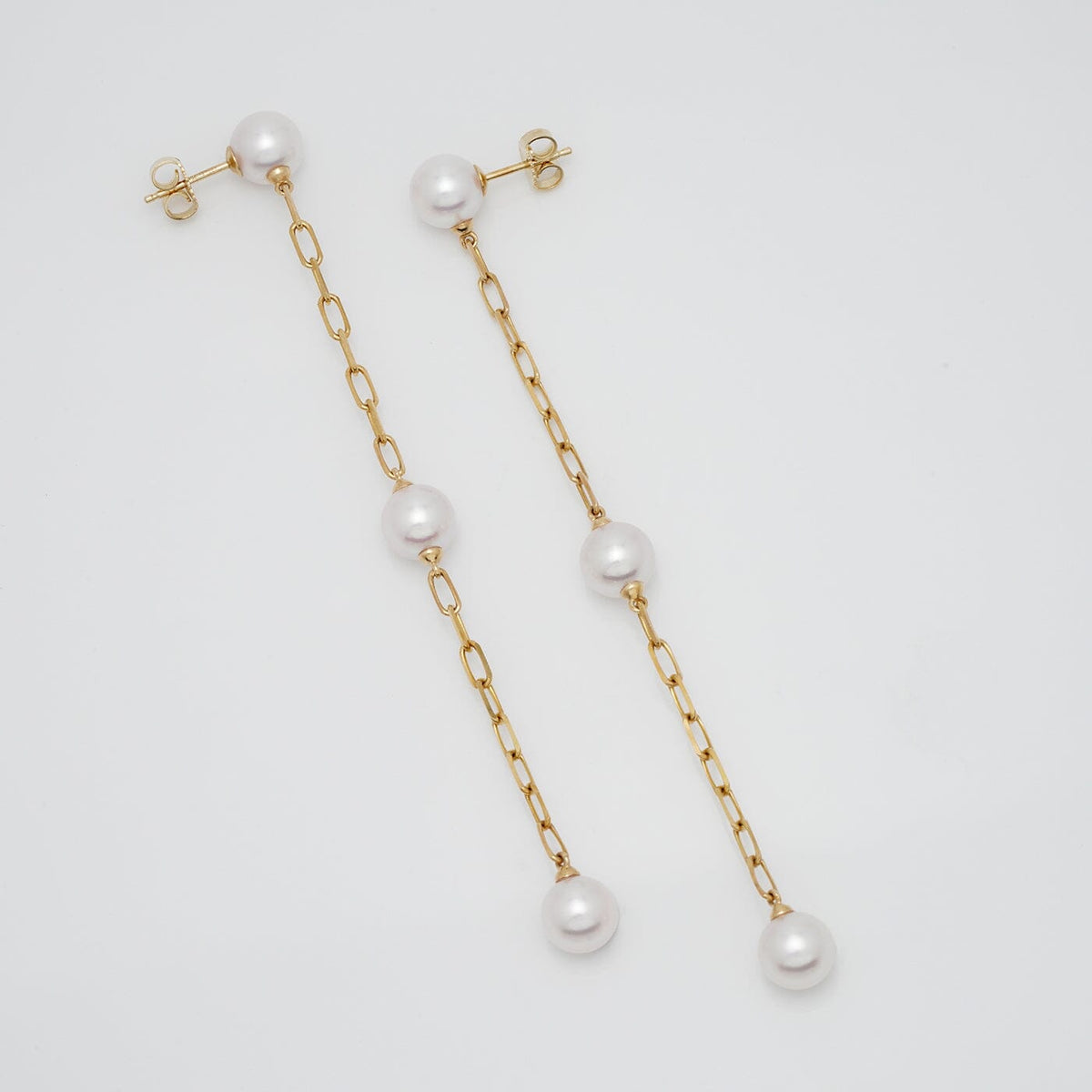 Assael Collection: 7.5-8.0 mm Akoya Pearl Dangle Earrings featuring three lustrous white akoya pearls on delicate gold chain links, elegant and sophisticated pearl earrings.