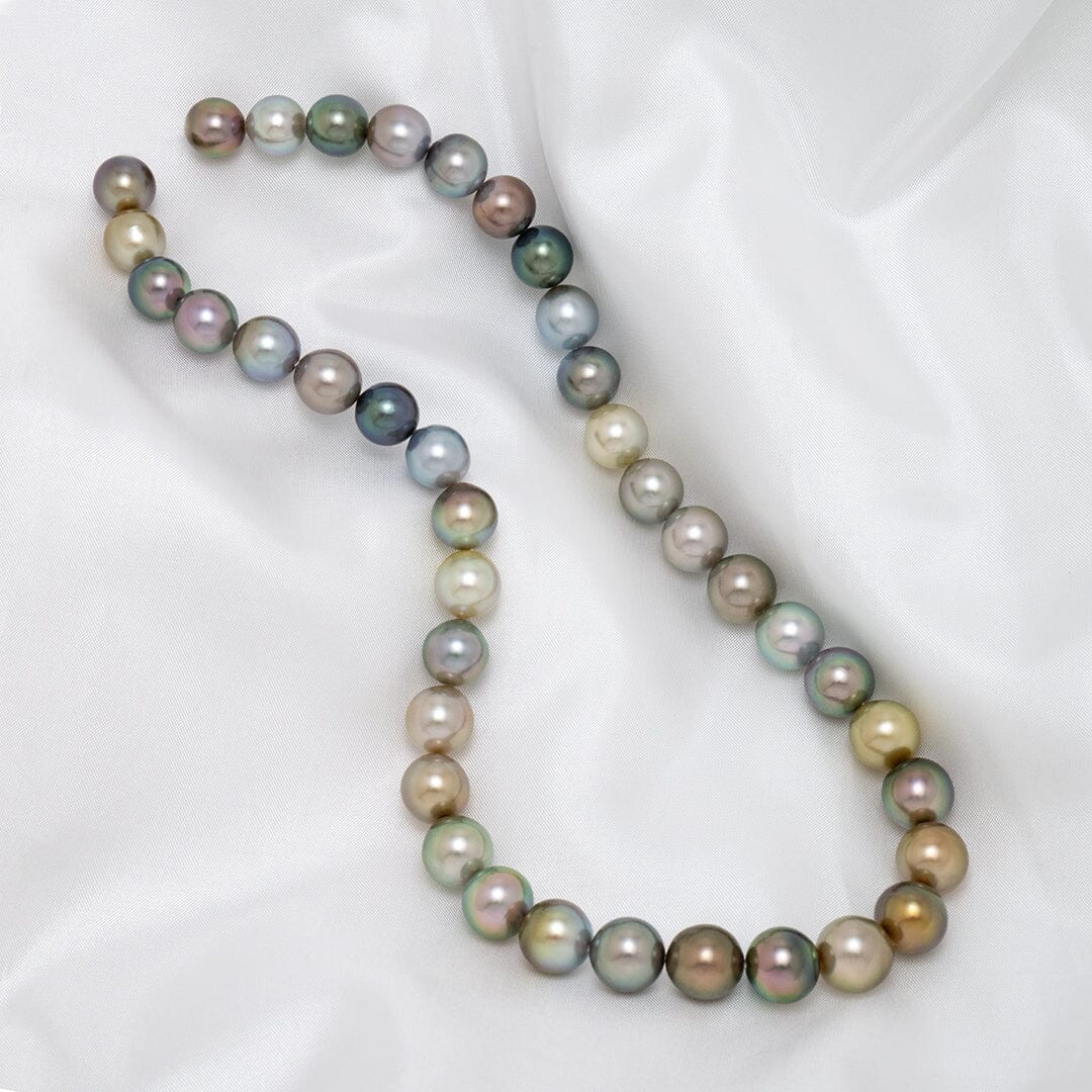 Assael Collection: 9.4–11.1 mm Fijian Pearl Necklace featuring a strand of multicolored, lustrous pearls in shades of green, gold, silver, blue, and lavender on a white silk background.