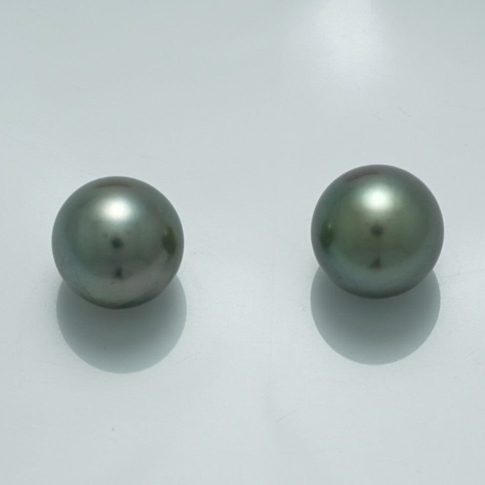 10.4 x 10.4 mm and 10.3 x 10.2 mm Fijian Pearl Pair with smooth, lustrous surfaces and subtle dark greenish-gray hues on a plain light background.