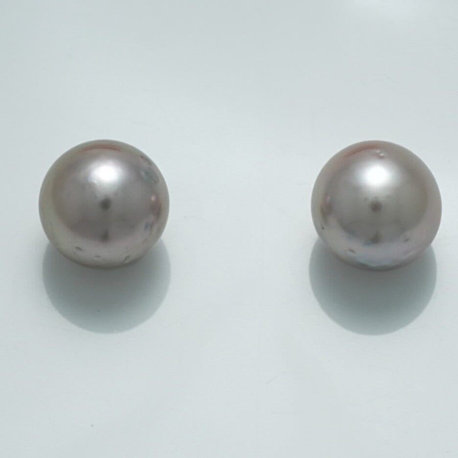 10.6 x 10.3 mm and 10.4 x 10.3 mm Fijian Pearl Pair featuring two lustrous, round, light-colored cultured pearls with smooth surfaces against a plain background.