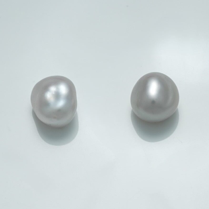 10.4 x 9.7 x 7.7 mm and 11.0 x 9.6 x 7.2 mm Fijian Keshi Pearl Pair with natural irregular shapes and lustrous white surface reflecting soft light on a pale background