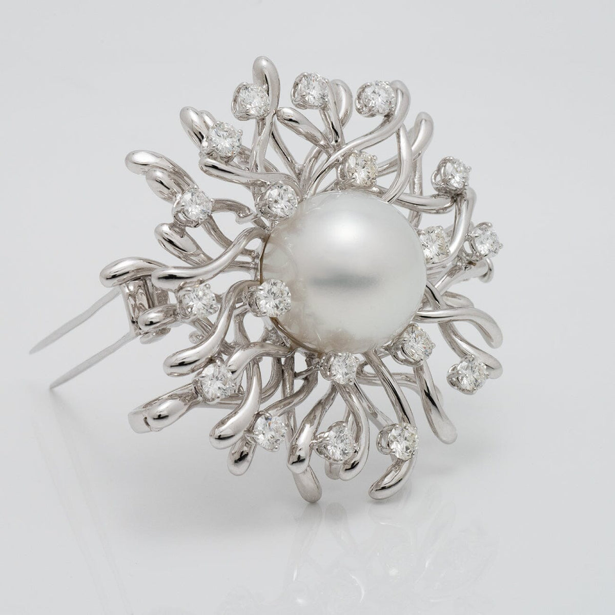 Assael Collection: 17.0 mm White South Sea Pearl and Diamond Brooch featuring a large white pearl surrounded by an intricate design of sparkling diamonds and white gold accents.