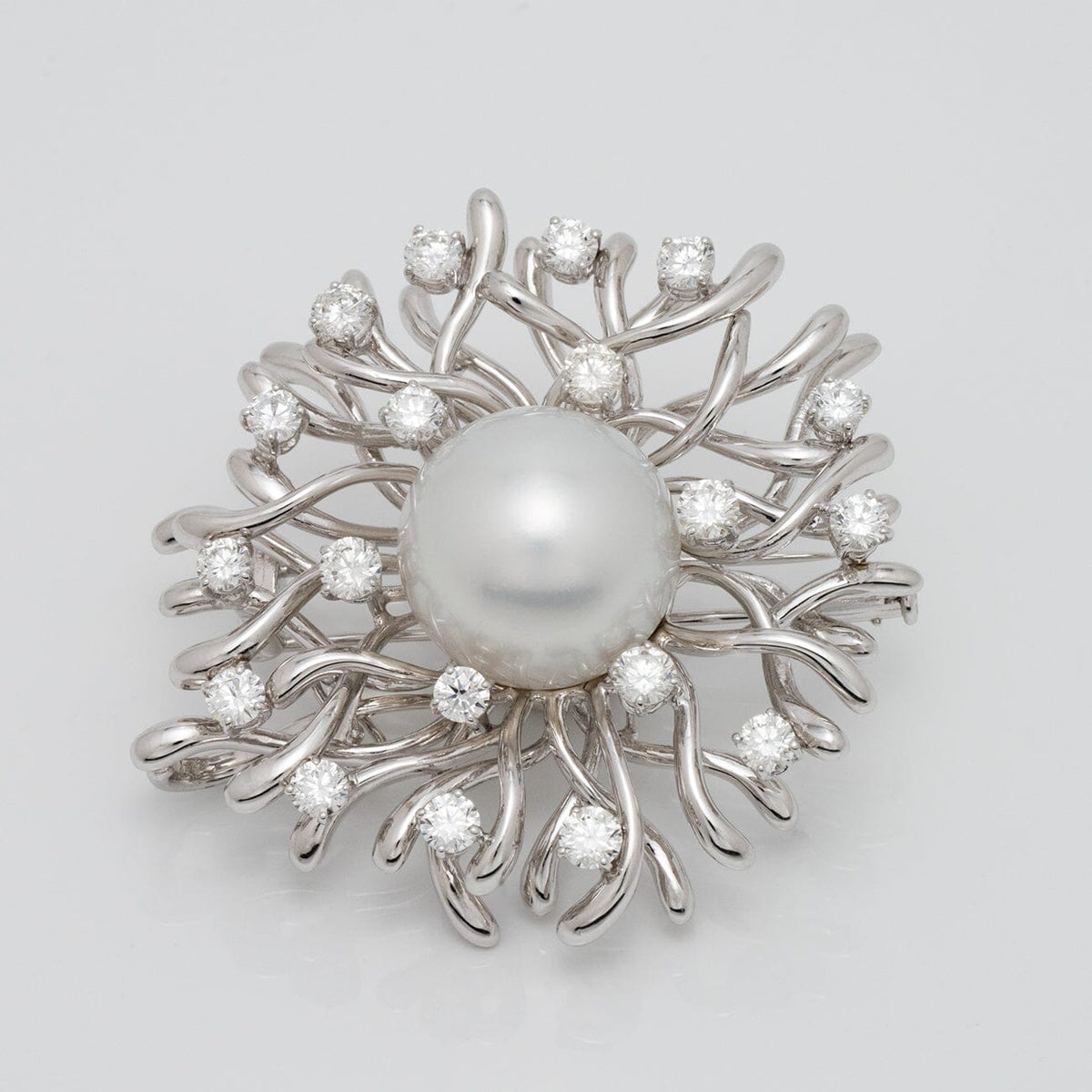Assael Collection: 17.0 mm White South Sea Pearl and Diamond Brooch featuring a large white pearl centerpiece surrounded by a swirl of white gold branches accented with sparkling diamonds.