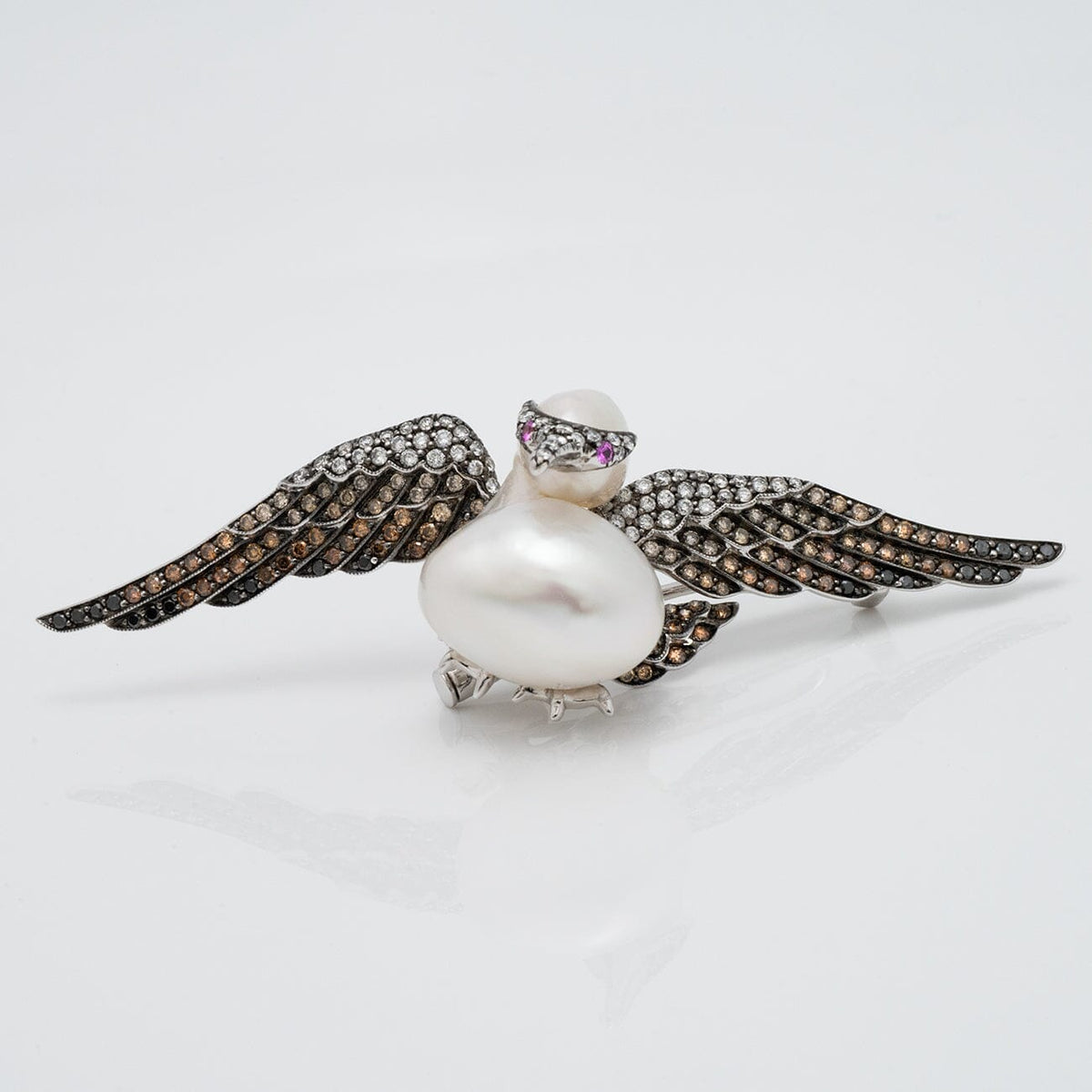 Assael Collection: 14.0 mm White South Sea Pearl, Diamond and Sapphire Brooch designed as a bird with outstretched wings set with diamonds and sapphires.