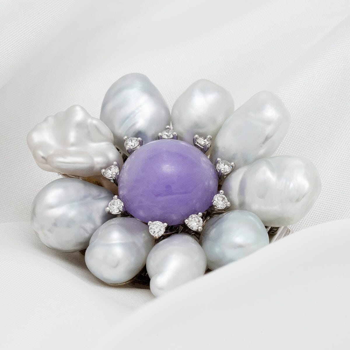Assael Collection: South Sea Keshi Pearl, Jade & Diamond Brooch featuring large white South Sea Keshi pearls surrounding a central lavender jade gemstone accented by small diamonds in a floral design.