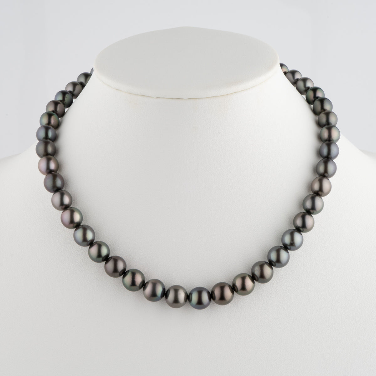Elegant 8.6-10.8 mm AA+/AAA Tahitian Round Pearl Necklace featuring lustrous black and dark grey cultured pearls with subtle iridescent hues, displayed on a white bust.