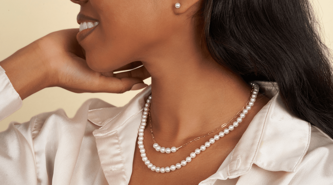 Model wearing pearl necklaces and pearl stud earrings. 