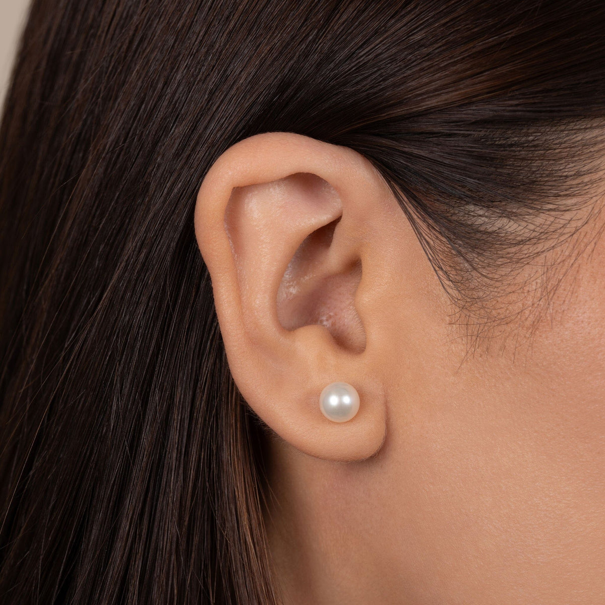 Close-up of an ear wearing 6.5-7.0 mm AAA White Freshwater Pearl Stud Earrings featuring a smooth white pearl stud, showcasing classic elegance and timeless style.