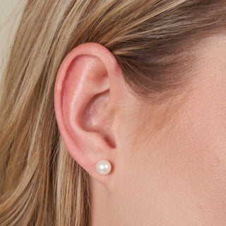 Close-up of a woman’s ear wearing 6.5-7.0 mm AAA White Freshwater Pearl Stud Earrings showcasing classic white freshwater pearls with a smooth, lustrous finish.