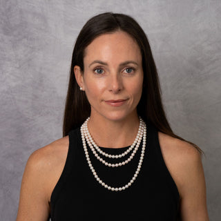 Woman wearing a 3-Piece Set of 7.0-7.5 mm AA+ White Akoya Pearls necklace and matching earrings, showcasing elegant white cultured pearl jewelry.