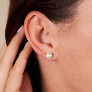 Close-up of a woman’s ear wearing elegant 7.5-8.0 mm AAA White Freshwater Pearl Stud Earrings, showcasing the lustrous white pearl on a simple stud setting.