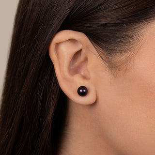 Close-up of a model wearing elegant 7.5-8.0 mm AAA Black Freshwater Pearl Stud Earrings, showcasing the deep lustrous black pearls with a smooth, polished finish.