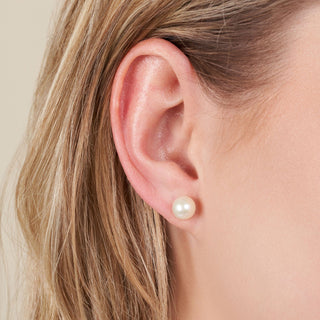 Close-up of a woman’s ear wearing 7.5-8.0 mm AAA White Freshwater Pearl Stud Earrings showcasing elegant white freshwater pearls.