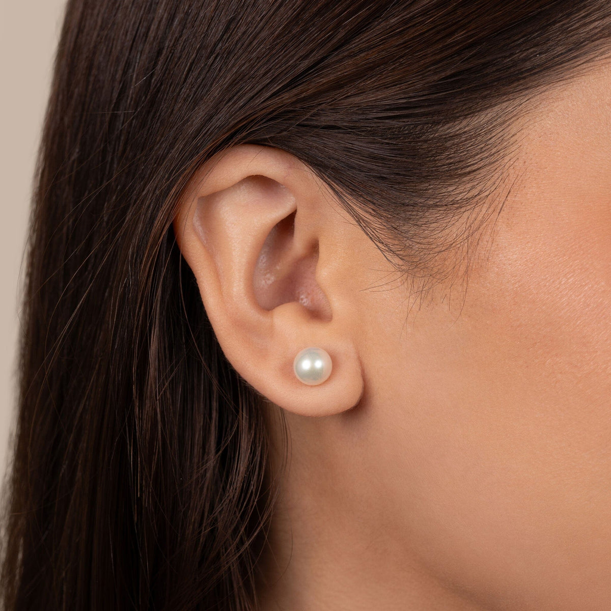 Close-up of an ear wearing elegant 7.5-8.0 mm AAA White Freshwater Pearl Stud Earrings with smooth, lustrous white pearls, perfect for a classic and refined look.