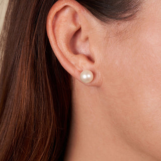Close-up of an ear wearing 8.5-9.0 mm AAA White Freshwater Pearl Stud Earrings, showcasing classic white pearls with a smooth, lustrous finish.