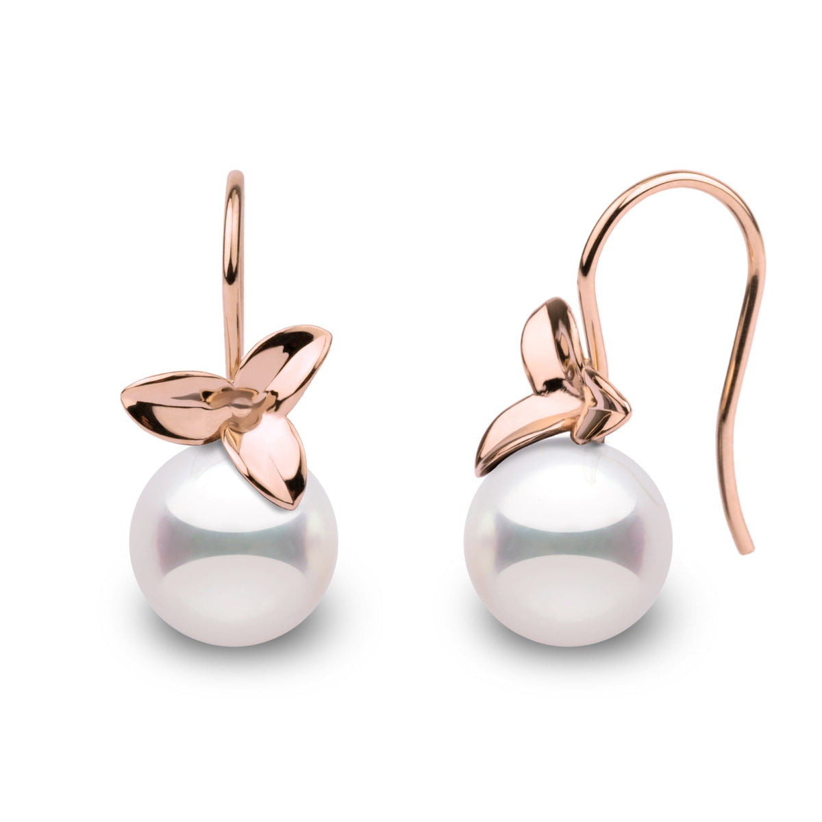 A pair of perfectly round Akoya pearl earrings with a floral design.