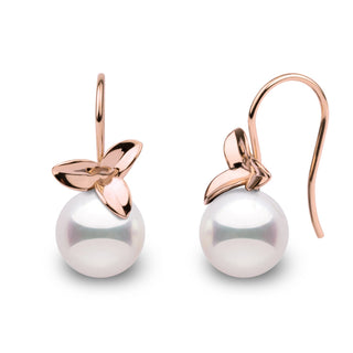 A pair of perfectly round Akoya pearl earrings with a floral design.