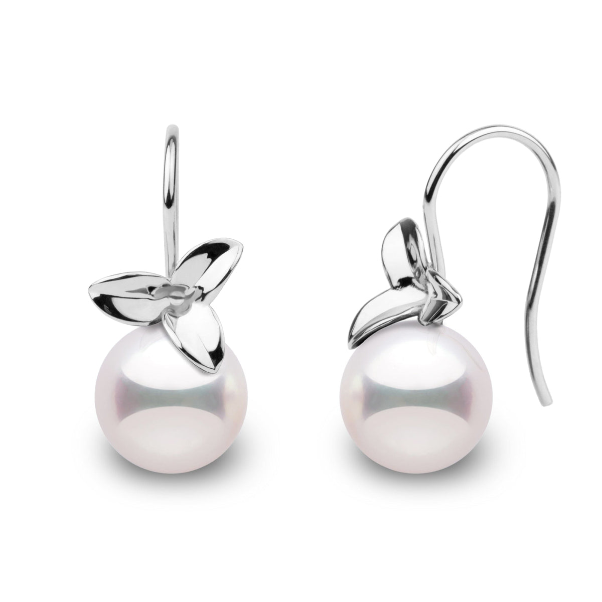 A pair of perfectly round Akoya pearl earrings with a floral design.