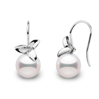 A pair of perfectly round Akoya pearl earrings with a floral design.