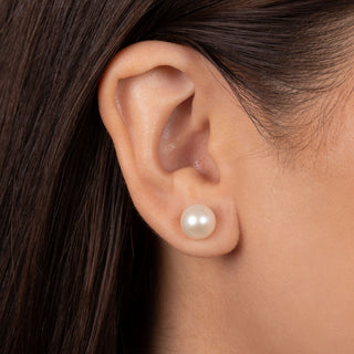 Close-up of a woman’s ear wearing 8.5-9.0 mm AAA White Freshwater Pearl Stud Earrings, showcasing the smooth, lustrous white pearl on the earlobe.