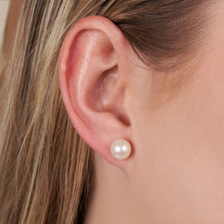 Close-up of a woman’s ear wearing 8.5-9.0 mm AAA White Freshwater Pearl Stud Earrings, showcasing the lustrous round white pearl on a simple stud setting.