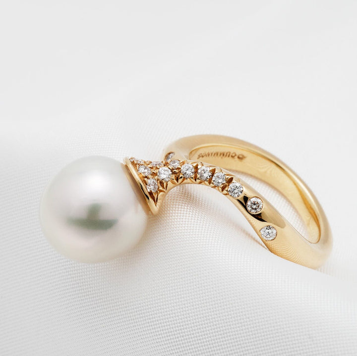 Assael Collection: 11.6 mm White South Sea Pearl and Diamond Ring featuring a large white pearl and a curved gold band adorned with round brilliant diamonds.
