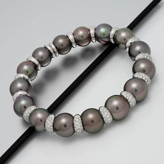 Assael Collection: 11.0-12.7 mm Tahitian Pearl and Diamond Bracelet featuring lustrous dark Tahitian pearls separated by sparkling diamond-encrusted spacers on a sleek surface.