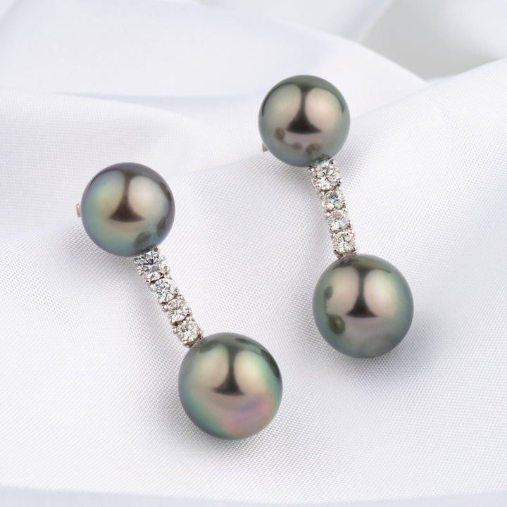 Assael Collection: 10.4–11.2 mm Tahitian Pearl and Diamond Earrings featuring lustrous black Tahitian pearls connected by a vertical row of sparkling diamonds on a white fabric background.