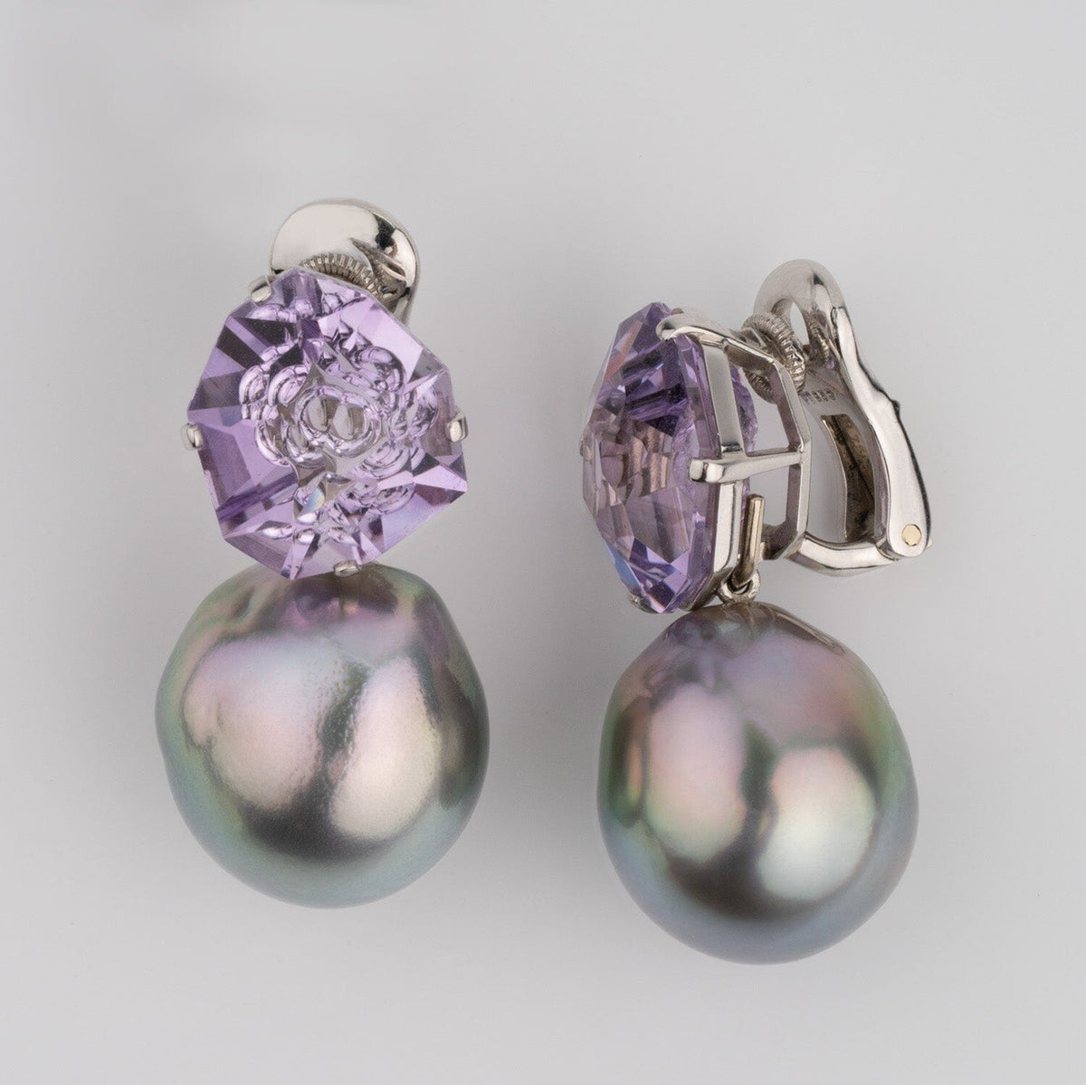 Assael Collection: 14.9–15.2 mm Tahitian Pearl and Amethyst Clip Earrings featuring large iridescent black pearls paired with faceted purple amethyst stones on 14K white gold clip backs.