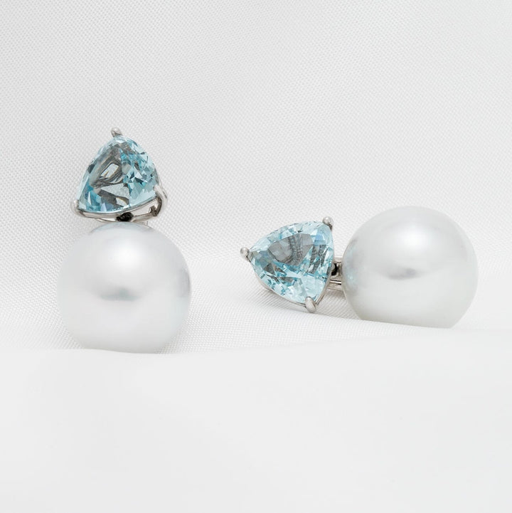 Assael Collection: 15 mm South Sea Pearl and Aquamarine Earrings featuring large white pearls paired with triangular aquamarine gemstones set in silver.
