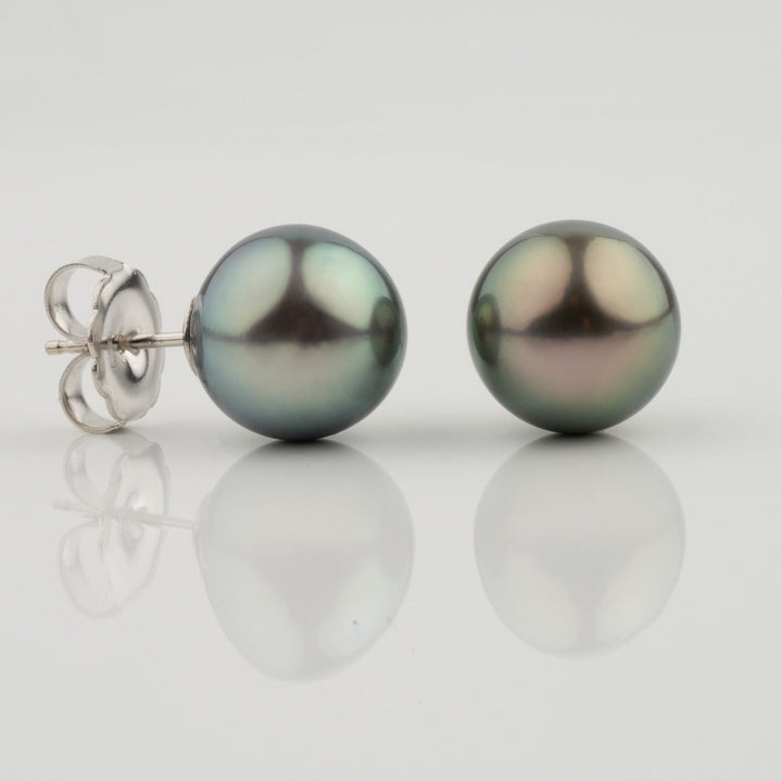 Assael Collection: 12.0–13.0 mm Tahitian Pearl Stud Earrings featuring lustrous dark tahitian pearls with subtle green and purple overtones set on silver posts against a white background.