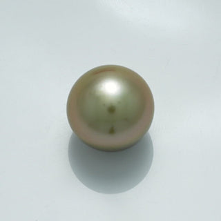 13.5 x 13.4 mm Fijian Pearl displaying a smooth, lustrous surface with subtle green and pink overtones on a light background, reflecting its fine quality and natural beauty.