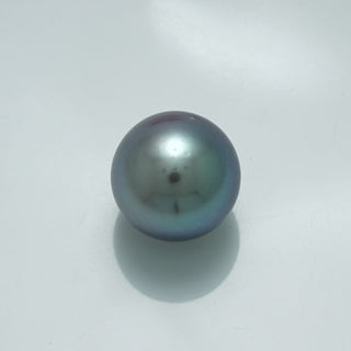 13.3 x 13.3 mm Fijian Pearl with a smooth surface and lustrous dark gray-green hues, reflecting subtle iridescent colors typical of fine cultured pearls.