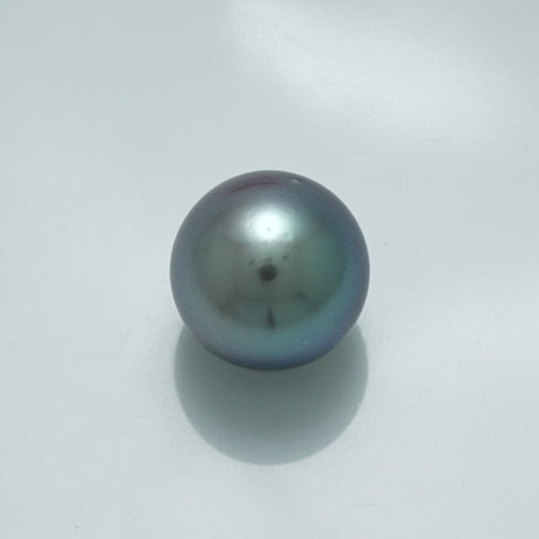 13.3 x 13.3 mm Fijian Pearl with a smooth surface and lustrous dark gray-green hues, reflecting subtle iridescent colors typical of fine cultured pearls.