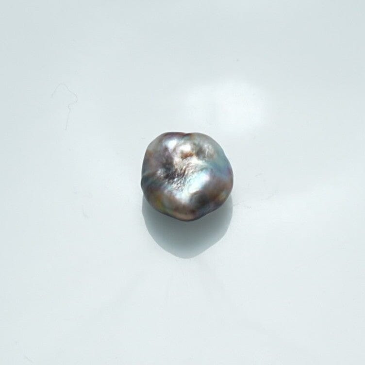 16.0 x 14.6 mm Fijian Keshi Pearl with an irregular, organic shape and lustrous surface displaying subtle iridescent hues of silver, gray, and hints of blue and green.