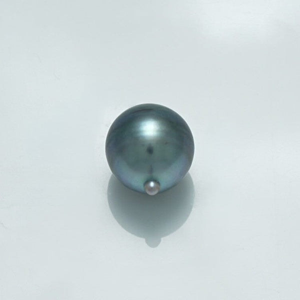 11.5 x 10.0 mm Fijian Drop Pearl with a smooth, lustrous surface showcasing natural hues of dark gray and subtle iridescent tones on a light background.