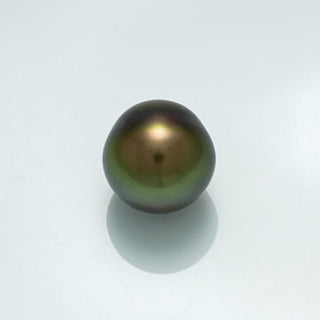 10.8 x 10.6 mm Fijian Baroque Pearl with a dark iridescent surface displaying green and gold hues, reflecting soft light on a smooth background.