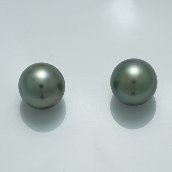 10.4 x 10.4 mm and 10.3 x 10.2 mm Fijian Pearl Pair with smooth, lustrous surfaces and subtle dark greenish-gray hues on a plain light background.