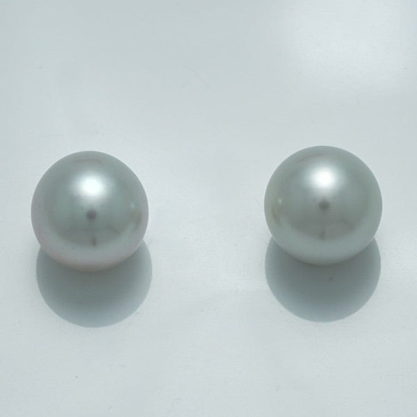 Close-up of a luminous pair of 11.1 x 10.7 mm and 11.1 x 10.7 mm Fijian Drop Pearl Pair with a smooth, reflective surface showcasing fine cultured pearls.