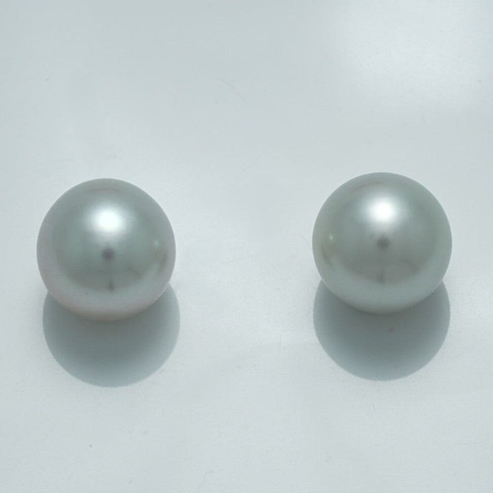 Close-up of a luminous pair of 11.1 x 10.7 mm and 11.1 x 10.7 mm Fijian Drop Pearl Pair with a smooth, reflective surface showcasing fine cultured pearls.