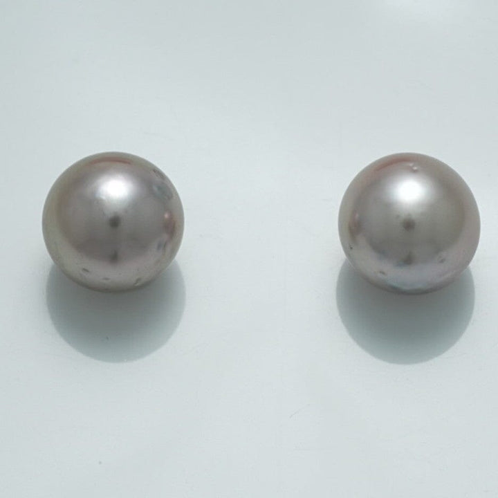 10.6 x 10.3 mm and 10.4 x 10.3 mm Fijian Pearl Pair featuring two lustrous, round, light-colored cultured pearls with smooth surfaces against a plain background.