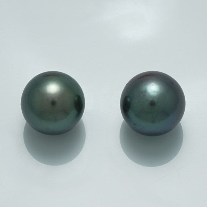 13.5 x 13.5 mm and 13.7 x 13.7 mm Fijian Round Pearl Pair with lustrous dark green and blue-black hues, showcasing fine cultured pearl quality.