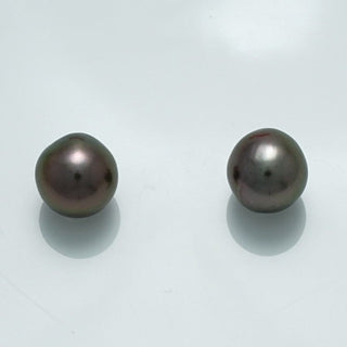 Pair of lustrous dark-colored pearls with smooth surfaces reflecting light, known as 9.8 x 9.6 x 9.2 mm and 19.7 x 9.5 x 9.4 mm Fijian Drop Pearl Pair