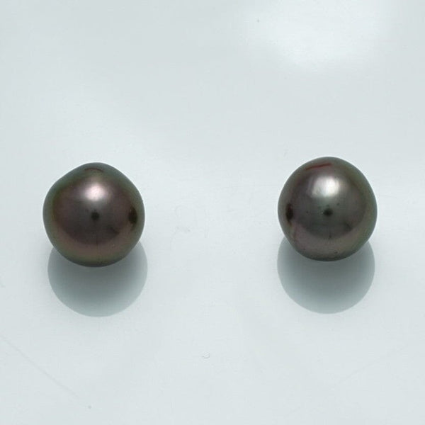Pair of lustrous dark-colored pearls with smooth surfaces reflecting light, known as 9.8 x 9.6 x 9.2 mm and 19.7 x 9.5 x 9.4 mm Fijian Drop Pearl Pair