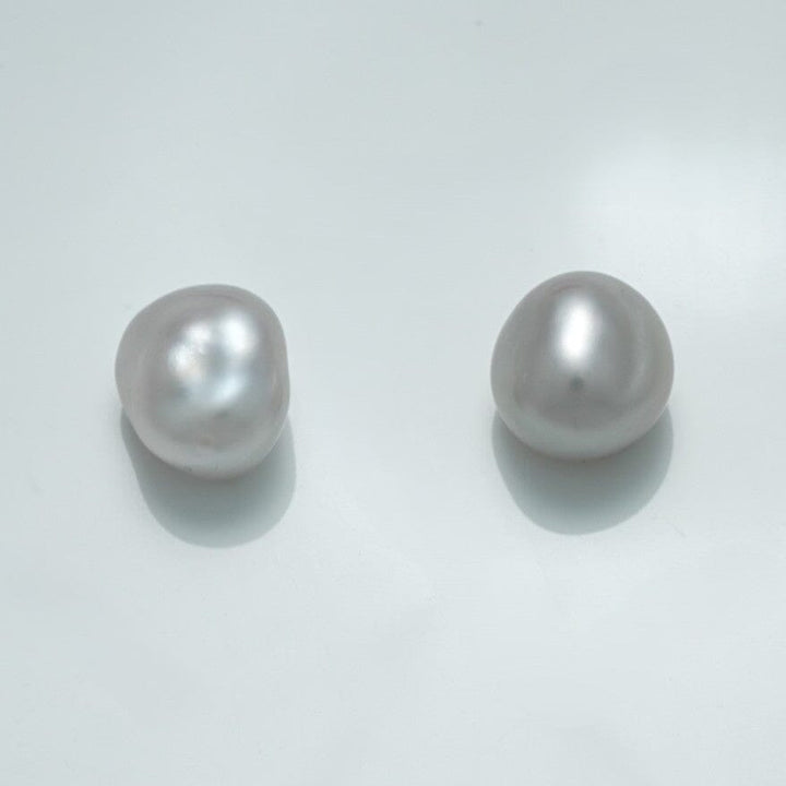10.4 x 9.7 x 7.7 mm and 11.0 x 9.6 x 7.2 mm Fijian Keshi Pearl Pair with natural irregular shapes and lustrous white surface reflecting soft light on a pale background