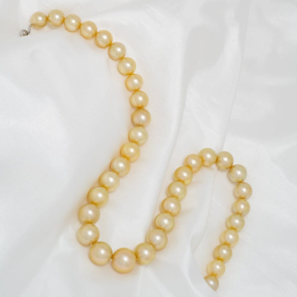 10.0–13.8 mm round Golden South Sea pearl necklace with a solid gold clasp, hand-knotted on silk