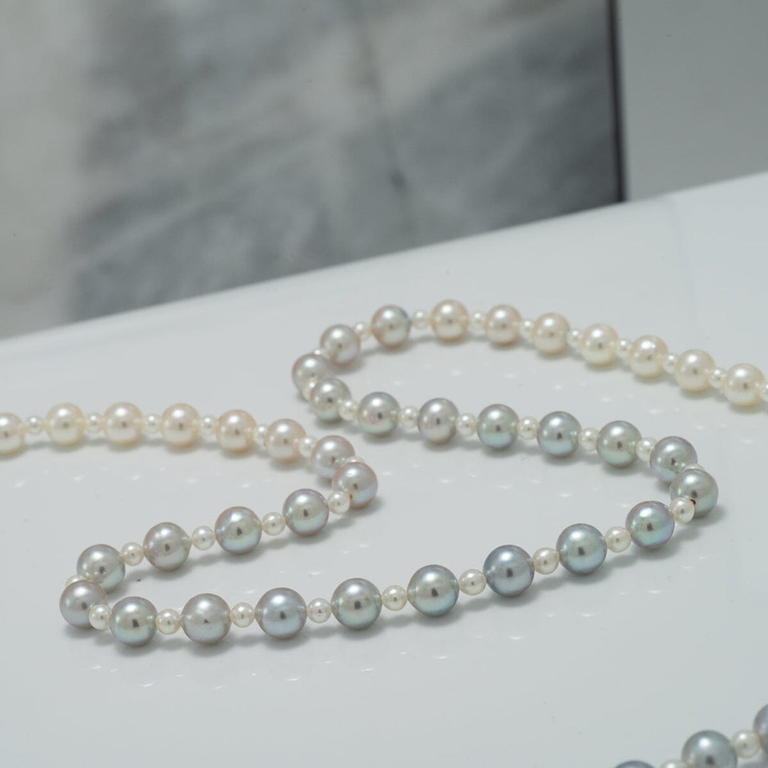 Close-up of a 2.0-5.5 mm Intense Blue Ombre Akoya Semi-Round Pearl Strand with smooth, lustrous pearls displaying a gradient from light to intense blue hues.